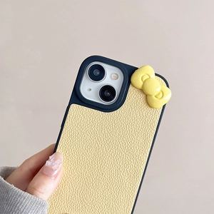 Detail of light yellow lychee pattern leather iPhone case with a 3D bow and camera protection