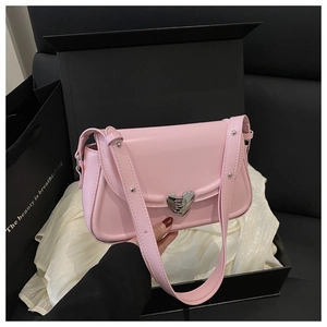 Detail of pink leather handbag featuring a creative heart-shaped metal buckle in a gift box