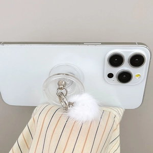Detail of luxury transparent phone grip with white faux fur pom-pom and silver chain