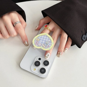 Detail of heart-shaped phone grip featuring blue plaid pattern and cute cartoon stickers