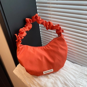 Bright orange nylon crescent shoulder bag with scrunchie strap and fashion label