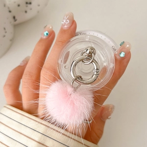 Close-up of clear phone grip featuring a luxury pink mink fur pom-pom and silver metal ring