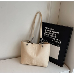 Detailansicht der beigefarbenen Canvas-Tasche mit Silberkette und Metallring-Verschluss