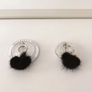 Close-up of black mink fur phone socket grip with silver ring on clear acrylic base