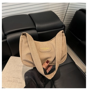 Dettaglio della borsa sottobraccio in tessuto kaki strutturato con stile a mezzaluna
