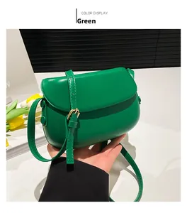 Detailed view of emerald green saddle bag texture with adjustable strap and side button