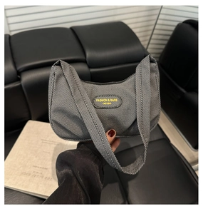 Vista ravvicinata di una borsa sottobraccio grigia a trama con design a pieghe