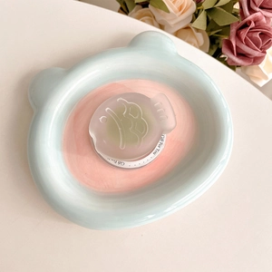 Detail of blue bear-shaped ceramic dish with fish charm and Gift For You card