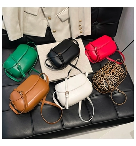 Selection of retro saddle bags in assorted colors and leopard print on a leather background