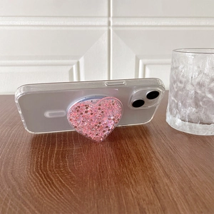 Detail van een roze glitter hartvormige magnetische telefoonhouder op hoesje