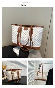 Detail der Vintage-Tragetasche mit braunem Blumenmuster und Metalllogo auf weißem Canvas