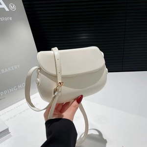 Chic cream white saddle crossbody bag with gold buckle and adjustable strap