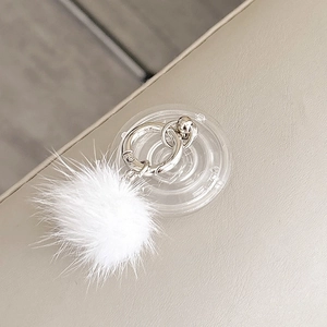 Macro shot of a white mink fur pompom phone grip with silver lobster clasp and clear ring