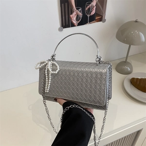 Silver woven shoulder bag with pearl bow and circular handle for elegant women