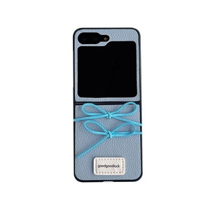 Stilvolle blaue Lederhülle für Klapphandy mit süßen Schleifen und aufgenähtem Etikett.