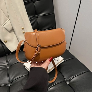 Vintage brown leather saddle shoulder bag with adjustable strap and caramel finish