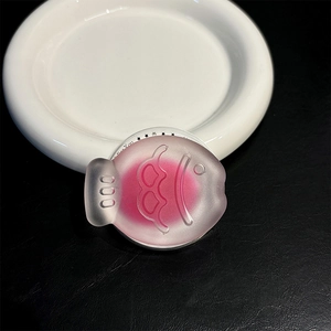 Detail of pink frosted taiyaki fish phone socket with embossed 000 texture on white plate