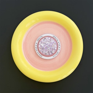 Detailweergave van ronde magnetische telefoonhouder met roze glitters en tekst
