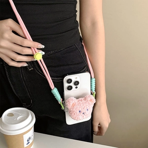 Detail of pink woven crossbody phone strap with cute plush bear on clear back clip