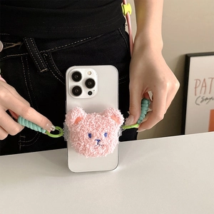Detail of pink plush bear phone holder with colorful braided crossbody strap and green clip