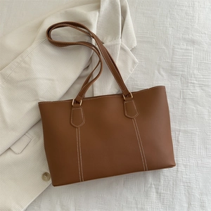 Minimalist caramel brown tote bag with contrast stitching and slim shoulder straps