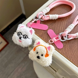 Macro view of plush puppy phone charms with pink braided rope and colorful headphones