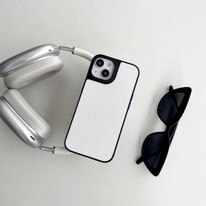 Detail of white litchi leather phone case with black lens frame and lifestyle accessories