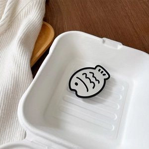 Detail of cute fish-shaped phone grip and mirror accessory inside a creative gift box