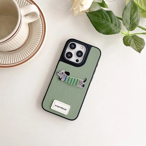 Dettaglio custodia iPhone in pelle grigio-verde con ricamo bassotto ed etichetta goodluck