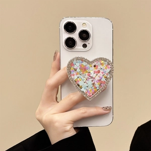 Glittering star sequins heart phone socket grip with rhinestones on a white smartphone