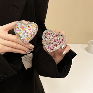 Macro shot of heart-shaped phone grip with sparkling sequins and rhinestone border