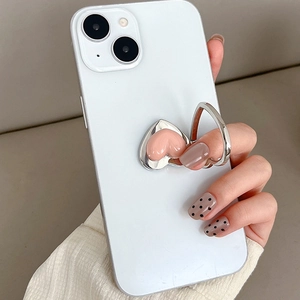 Pink heart-shaped phone ring holder with silver metal finish on white mobile phone