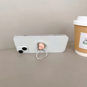 Pink heart phone ring stand with silver pull ring mounted on white smartphone back