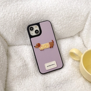 Dettaglio della custodia iPhone in pelle viola con ricamo a bassotto su tessuto morbido