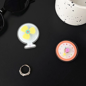 Detail of colorful acrylic charms with a metallic silver ring on a dark background