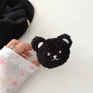 Detail of black plush bear phone clip with textured loop pile and white embroidered face