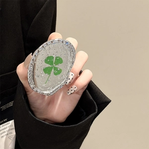 Silver foil floral oval phone grip with green clover design held by a person