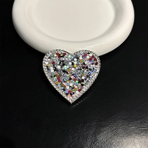Detail of heart-shaped phone grip with silver rhinestones and multi-color glitter