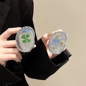Oval silver phone grip with real green clover and blue flowers in clear resin