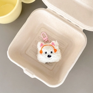 Detail of a white fluffy puppy plush headphone case in a gift box with a pink carabiner