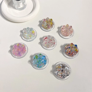 Dettaglio di otto supporti per telefono a forma di zampa di gatto con glitter