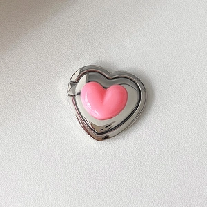 Close-up of pink 3D heart phone ring holder with silver metal foldable kickstand