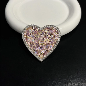 Close-up of heart-shaped phone grip with sparkling sequins and diamond-studded edges
