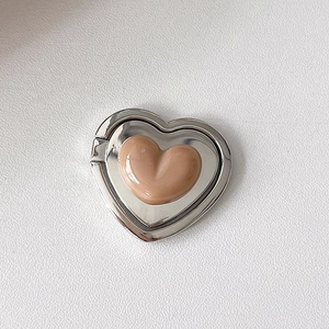 Detail view of heart-shaped phone ring stand with pink glossy finish and silver plating
