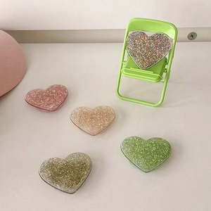 Glittery heart-shaped expandable phone grip holder in multiple vibrant colors