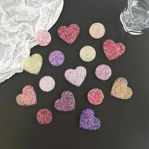 Glitter heart and round shape expanding grip sockets for mobile phones on black background