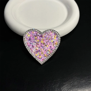 Macro shot of glittery heart phone grip with sparkling sequins and rhinestone border