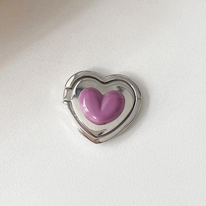 Close-up of a silver metal heart-shaped phone ring holder with a purple resin center