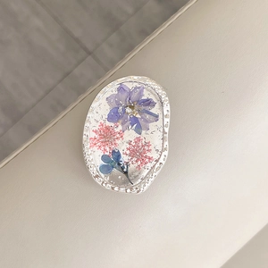 Detail of flower phone grip with silver foil and real pressed petals in resin