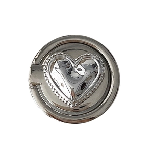Silver plated heart phone ring stand with beaded texture on a white background